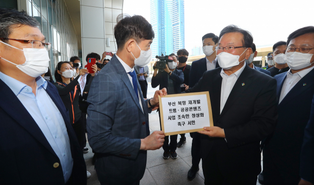 25일 부산을 방문한 김부겸 국무총리가 부산항국제여객터미널 앞에서 부산지역 시민사회단체로부터 북항 재개발 트램·공공콘텐츠 사업의 조속한 정상화를 촉구하는 서한을 전달받고 있다. 정종회 기자 jjh@