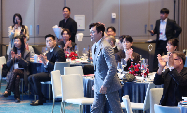 2025 부일영화상이 부산 해운대구 시그니엘 부산 그랜드볼룸에서 열렸다. 남우주연상을 받은 이병헌이 동료 영화인들의 축하를 받으며 무대로 오르고 있다. 부산일보DB