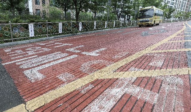 부산 북구 만덕동 상학로 어린이보호구역에 붉은색 미끄럼방지 포장이 되어 있다. 미끄럼방지 포장은 마모속도가 빨라 노후화시 마찰력 감소로 위험. 이 구간은 경사가 심해 빗길에 사고가 우려된다. 김종진 기자 kjj1761@