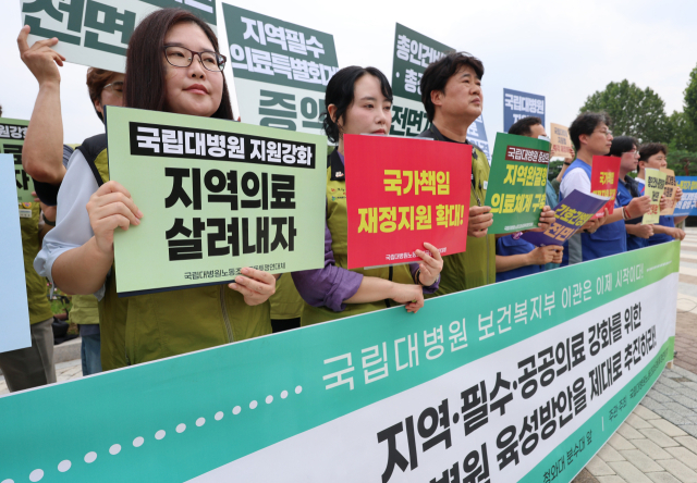 8월 19일 서울 종로구 청와대 사랑채 앞에서 국립대병원 노동조합 공동투쟁 연대체 주최로 열린 '지역·필수·공공의료 강화를 위한 국립대병원 육성 촉구 국립대병원연대체 기자회견'에서 참가자들이 손팻말을 들고 있는 모습. 연합뉴스
