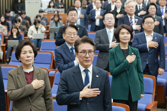 더불어민주당 김민석 대표 등 지도부와 의원들이 27일 국회에서 조희대 대법원장에 대한 국정조사 추진 등을 논의하기 위해 열린 의원총회에 참석해 국기에 경례하고 있다. 연합뉴스
